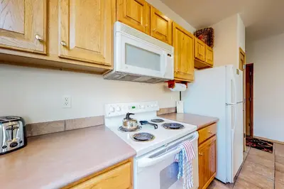 a kitchen with a stove and a white refrigerator at Tarn Landing B7 in Frisco