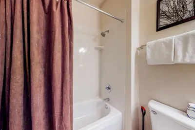 a bathroom with a shower curtain and a bath tub at Tarn Landing B7 in Frisco
