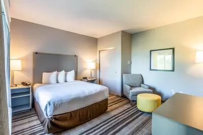 a hotel room with a bed and a chair at Hawthorn Extended Stay by Wyndham Loveland in Johnstown