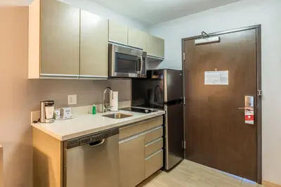 a kitchen with a refrigerator and a sink at Hawthorn Extended Stay by Wyndham Loveland in Johnstown