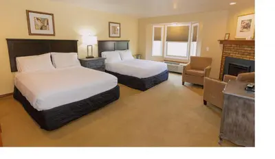 a hotel room with two beds and a fireplace at Hilltop Inn Broomfield Denver in Broomfield