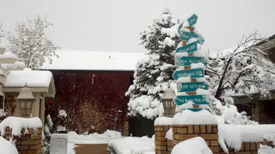 a snow covered christmas tree in front of a house at Hilltop Inn Broomfield Denver in Broomfield
