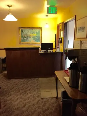 a waiting room with a desk and an exit sign at Hilltop Inn Broomfield Denver in Broomfield