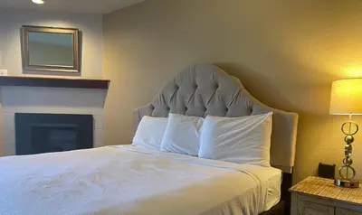 a bedroom with a large white bed with a headboard at Hilltop Inn Broomfield Denver in Broomfield