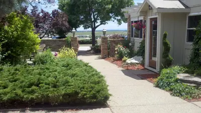 a sidewalk leading to a house with a garden at Hilltop Inn Broomfield Denver in Broomfield