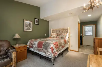a bedroom with a bed and a chair at Ponderosa Lodge in Estes Park