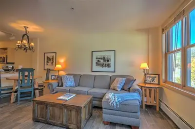 a living room with a couch and a table at Cozy And Quaint 1 Bedroom Condo In The Heart Of River Run Village in Keystone