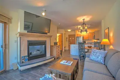 a living room with a couch and a fireplace at Cozy And Quaint 1 Bedroom Condo In The Heart Of River Run Village in Keystone