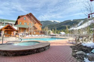 a swimming pool in front of a house at Cozy And Quaint 1 Bedroom Condo In The Heart Of River Run Village in Keystone