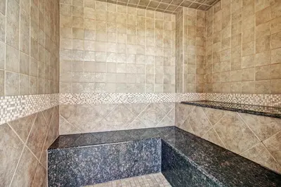 a bathroom with a large shower with brown tiles at 2311 Red Hawk Lodge Condo in Keystone