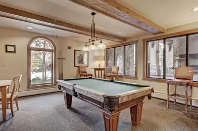 a pool table in a room with windows at 2311 Red Hawk Lodge Condo in Keystone