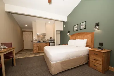 a bedroom with a large bed and a kitchen at The Maxwell Inn in Estes Park