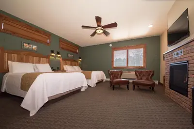 a hotel room with two beds and a flat screen tv at The Maxwell Inn in Estes Park