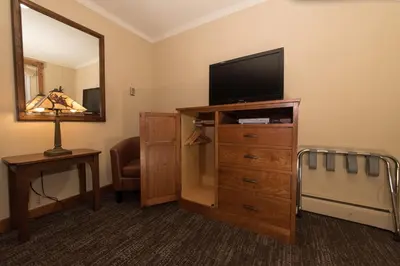 a hotel room with a flat screen tv on a dresser at The Maxwell Inn in Estes Park