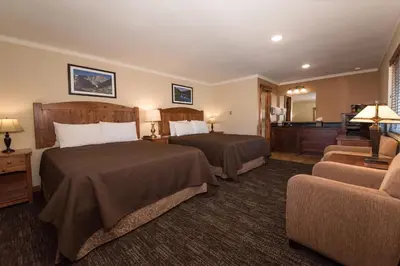a hotel room with two beds and a couch at The Maxwell Inn in Estes Park