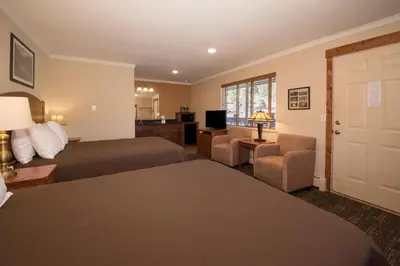 a hotel room with two beds and a television at The Maxwell Inn in Estes Park