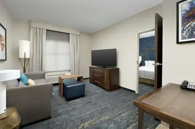 a hotel room with a couch and a flat screen tv at Homewood Suites By Hilton Denver Airport Tower Road in Denver