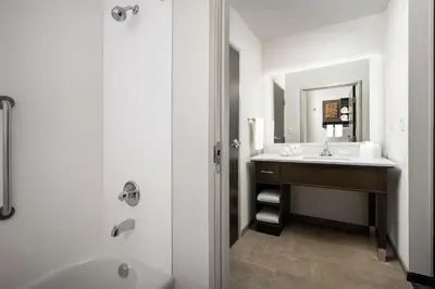 a bathroom with a sink and a tub and a mirror at Homewood Suites By Hilton Denver Airport Tower Road in Denver