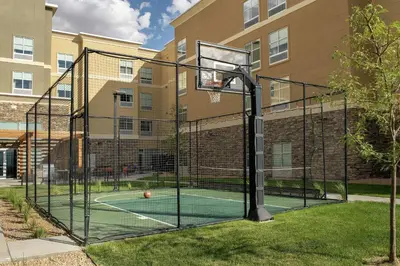a basketball hoop with a ball on a court in front of a building at Homewood Suites By Hilton Denver Airport Tower Road in Denver