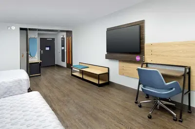 a hotel room with a bed and a chair and a tv at Tru By Hilton Denver Airport Tower Road in Denver