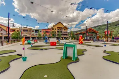 a playground with miniature golf courses in a town at 2 Bedroom Colorado Mountain Vacation Rental In River Run Village With Hot Tub Access And Walking Distance To Ski in Keystone