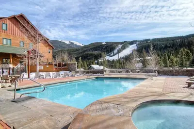 a large swimming pool in front of a ski resort at 2 Bedroom Colorado Mountain Vacation Rental In River Run Village With Hot Tub Access And Walking Distance To Ski in Keystone