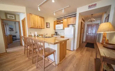 a kitchen with a island with chairs and a counter top at 2 Bedroom Colorado Mountain Vacation Rental In River Run Village With Hot Tub Access And Walking Distance To Ski in Keystone