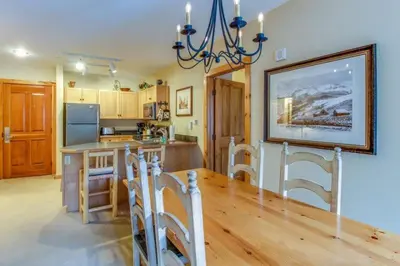 a kitchen with a wooden table and a dining room at 1 Bedroom Plus Murphy Mountain Condo In River Run Village With Hot Tub Access And Walking Distance To Ski in Keystone