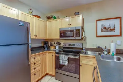 a kitchen with a refrigerator and a stove top oven at 1 Bedroom Plus Murphy Mountain Condo In River Run Village With Hot Tub Access And Walking Distance To Ski in Keystone