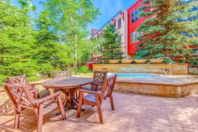a patio with a table and chairs and a fountain at 1 Bedroom Mountain Chic Condo In River Run Village Just A Short Walk To Shopping, Dining, And Skiing in Keystone