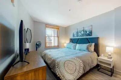 a bedroom with a bed and a flat screen tv at 1 Bedroom Mountain Chic Condo In River Run Village Just A Short Walk To Shopping, Dining, And Skiing in Keystone