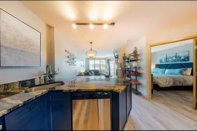 a kitchen with a sink and a bedroom with a bed at 1 Bedroom Mountain Chic Condo In River Run Village Just A Short Walk To Shopping, Dining, And Skiing in Keystone