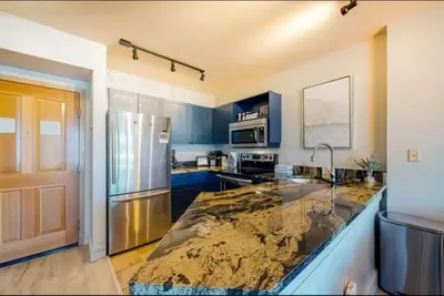 a kitchen with blue cabinets and a granite counter top at 1 Bedroom Mountain Chic Condo In River Run Village Just A Short Walk To Shopping, Dining, And Skiing in Keystone