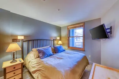 a bedroom with a bed and a tv on the wall at 1 Bedroom Mountain Condo In River Run Village With Beautiful Mountain Views And Walking Distance To Ski in Keystone