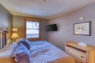 a bedroom with a bed and a tv on the wall at 1 Bedroom Mountain Condo In River Run Village With Beautiful Mountain Views And Walking Distance To Ski in Keystone