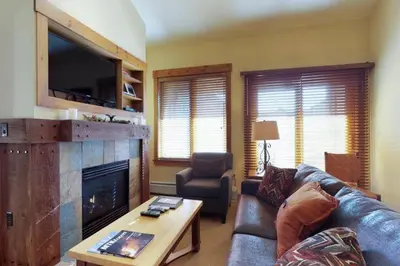 a living room with a leather couch and a fireplace at 2 Bedroom Colorado Vacation Rental Situated In River Run Village Steps From The Summit Express Gondola in Keystone