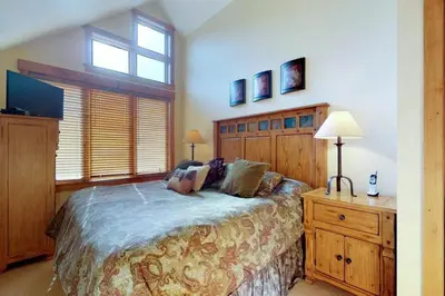 a bedroom with a bed and a dresser and a window at 2 Bedroom Colorado Vacation Rental Situated In River Run Village Steps From The Summit Express Gondola in Keystone