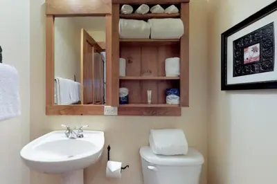 a bathroom with a sink and a toilet and a mirror at 2 Bedroom Colorado Vacation Rental Situated In River Run Village Steps From The Summit Express Gondola in Keystone