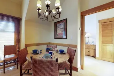 a dining room with a table with chairs and a chandelier at 2 Bedroom Colorado Vacation Rental Situated In River Run Village Steps From The Summit Express Gondola in Keystone