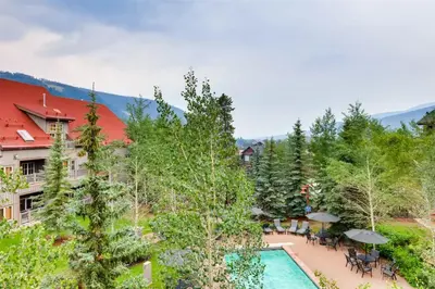 an aerial view of a resort with a pool and trees at 1 Bedroom Colorado Vacation Rental In River Run Village Steps From The Summit Express Gondola in Keystone
