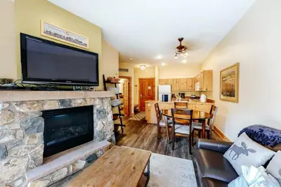 a living room with a fireplace with a flat screen tv at 1 Bedroom Colorado Vacation Rental In River Run Village Steps From The Summit Express Gondola in Keystone