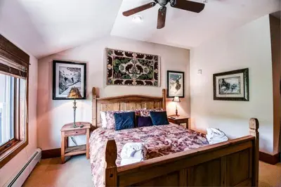 a bedroom with a large bed and a ceiling fan at Premier 4 Bedroom Ski In, Ski Out Lone Eagle Condo With The Best Access To Skiing In Keystone in Keystone