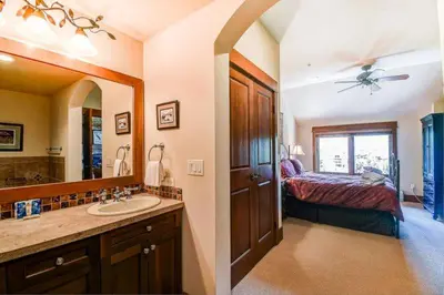 a bathroom with a sink and a bedroom with a bed at Premier 4 Bedroom Ski In, Ski Out Lone Eagle Condo With The Best Access To Skiing In Keystone in Keystone