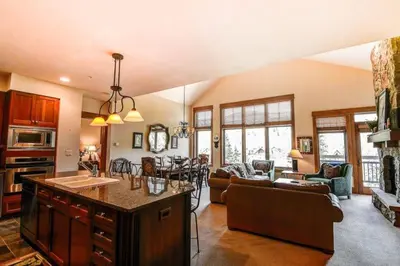 a large kitchen and living room with a couch and a table at Premier 4 Bedroom Ski In, Ski Out Lone Eagle Condo With The Best Access To Skiing In Keystone in Keystone