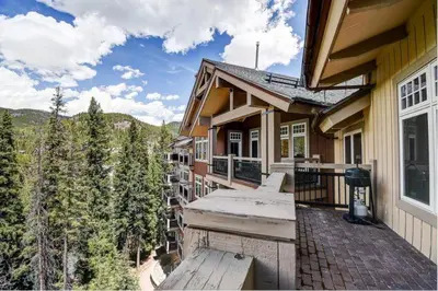 a balcony of a house with a view of the mountains at Premier 4 Bedroom Ski In, Ski Out Lone Eagle Condo With The Best Access To Skiing In Keystone in Keystone