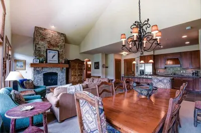 a dining room and living room with a wooden table at Premier 4 Bedroom Ski In, Ski Out Lone Eagle Condo With The Best Access To Skiing In Keystone in Keystone