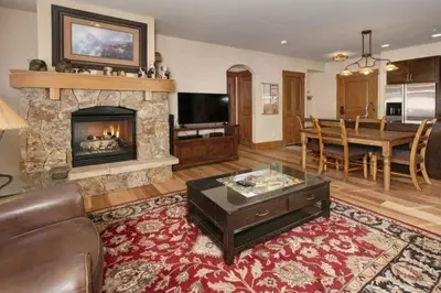a living room with a fireplace and a dining room at Premier 2 Bedroom Ski In, Ski Out Lone Eagle Condo With The Best Access To Skiing In Keystone in Keystone