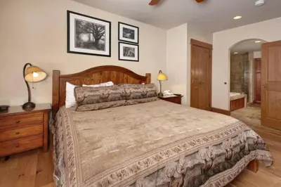 a bedroom with a large bed and a bathroom at Premier 2 Bedroom Ski In, Ski Out Lone Eagle Condo With The Best Access To Skiing In Keystone in Keystone