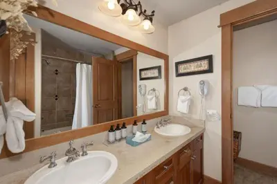 a bathroom with two sinks and a large mirror at Premier 2 Bedroom Ski In, Ski Out Lone Eagle Condo With The Best Access To Skiing In Keystone in Keystone