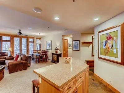 a kitchen and living room with a couch and a table at Premier 2 Bedroom Ski In, Ski Out Vacation Rental At The Timbers With The Best Access To Skiing In Keystone in Keystone
